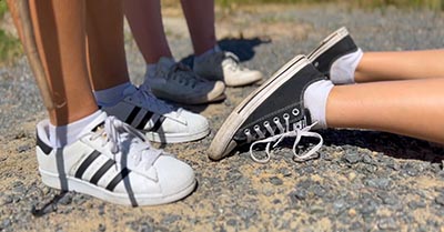 A close-up image of the ground occupied by three students.