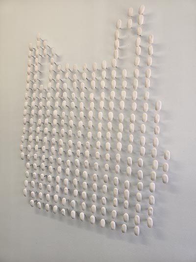 The art installation being displayed on a white wall.