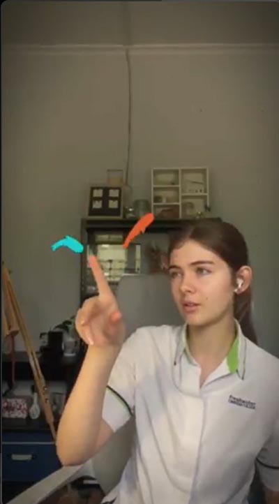 An image of a student with one index finger pointing upward, a thick light blue stroke extending from the left, and an orange stroke extending from the right
