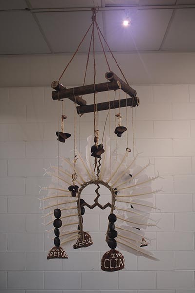 A hanging art installation made with coconut, feathers, natural fibres and wood. 
