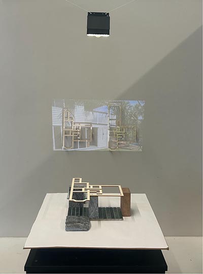 An installation combining a wall projection with physical materials displayed in the foreground.