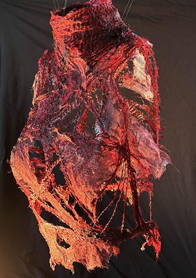 A red textile sculpture suspended overhead.