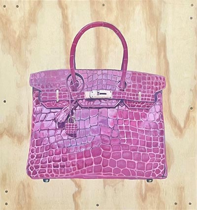 A pink handbag featuring a crocodile skin-like texture.