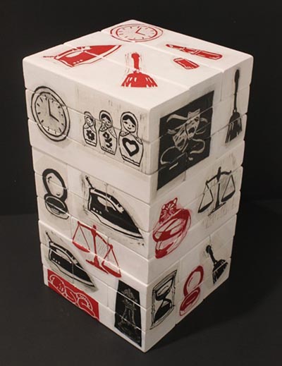 A stack of white Jenga blocks with printed symbols, including a clock, iron, hourglass and others, in either red or black.