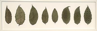 A framed artwork featuring 8 series of textile leaf-like forms, each adorned with a unique geometric pattern.