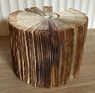 A sculpture of book pages shaped into a tree stump.