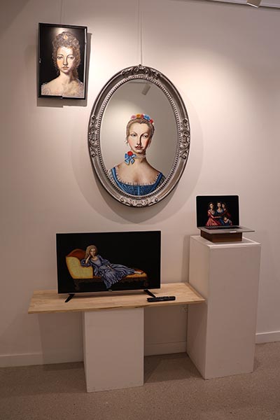 Portrait paintings displayed on various objects, including a photo frame, a Victorian-style mirror, a television screen and a laptop screen.